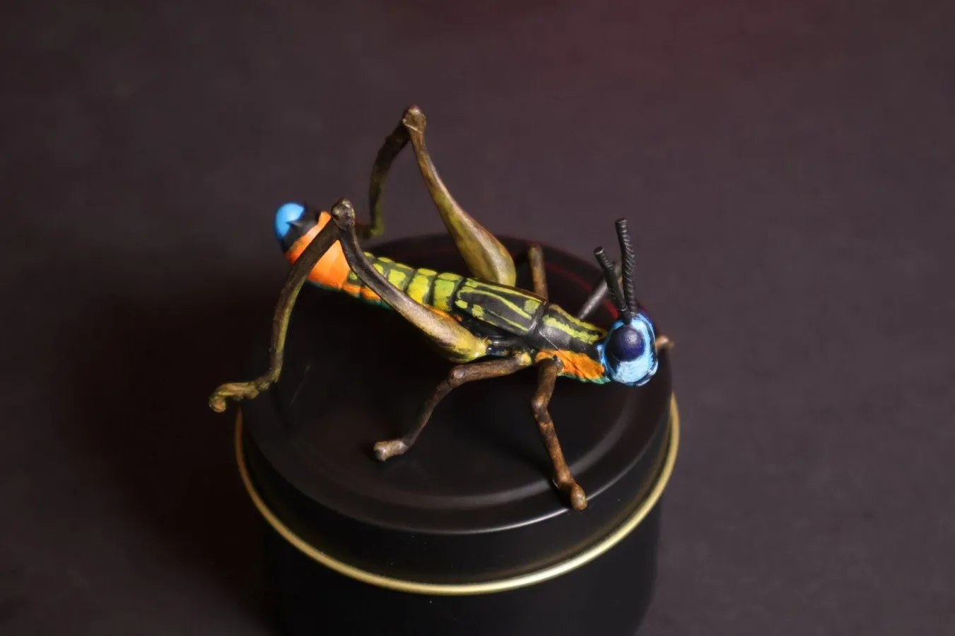 Réplica de saltamontes pintada a mano sobre base